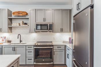 A kitchen with stainless steel appliances and white cabinets